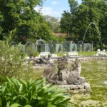 Teich in einem Schlosspark. Der sind mehrere wasserspeihende Figuren im See.
